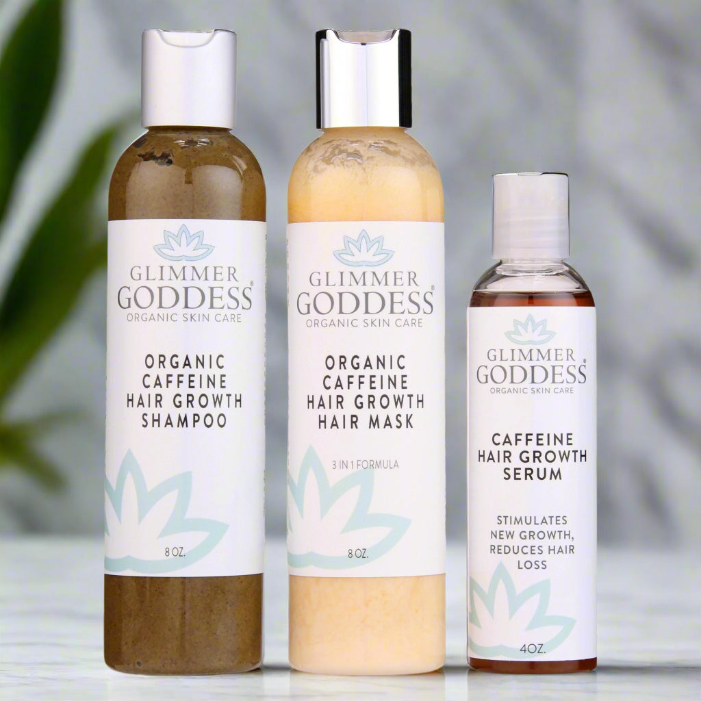 Three bottles of Glimmer Goddess organic skin care products on a white background