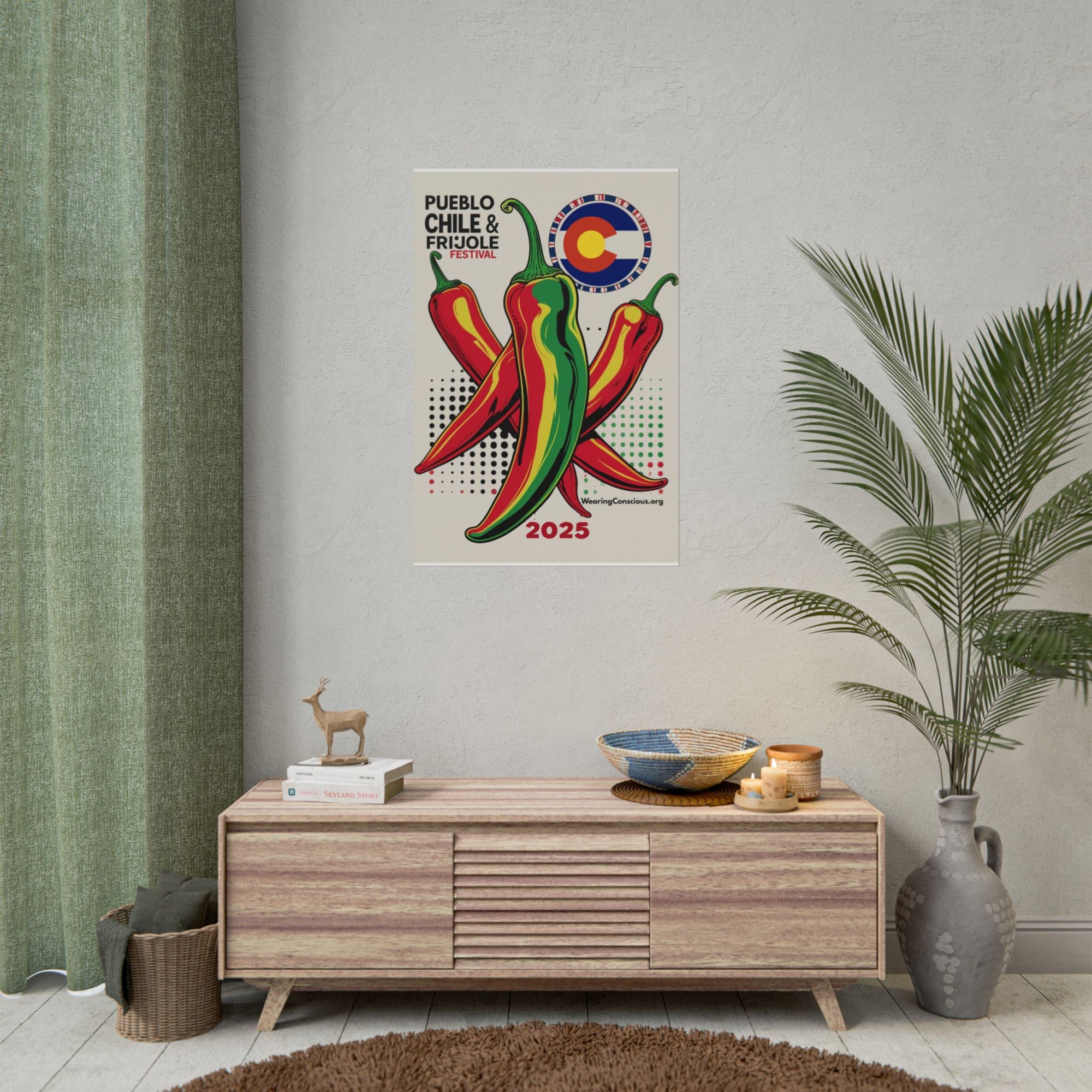 Poster of peppers on a wall above a wooden cabinet with decorative items.