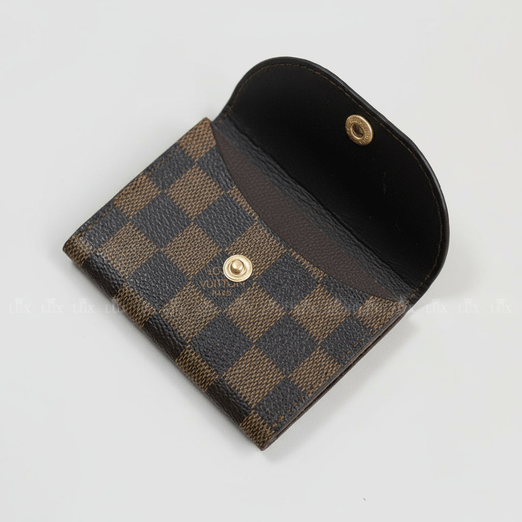 Checkered wallet with metallic buttons on a beige background