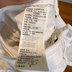 Close-up of a white garment with a label on a wooden surface