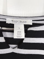 Close-up of a striped knit garment with a visible neck label reading White House | Black Market and a size tag marked S.