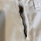 Close-up of white jean pants zipper area
