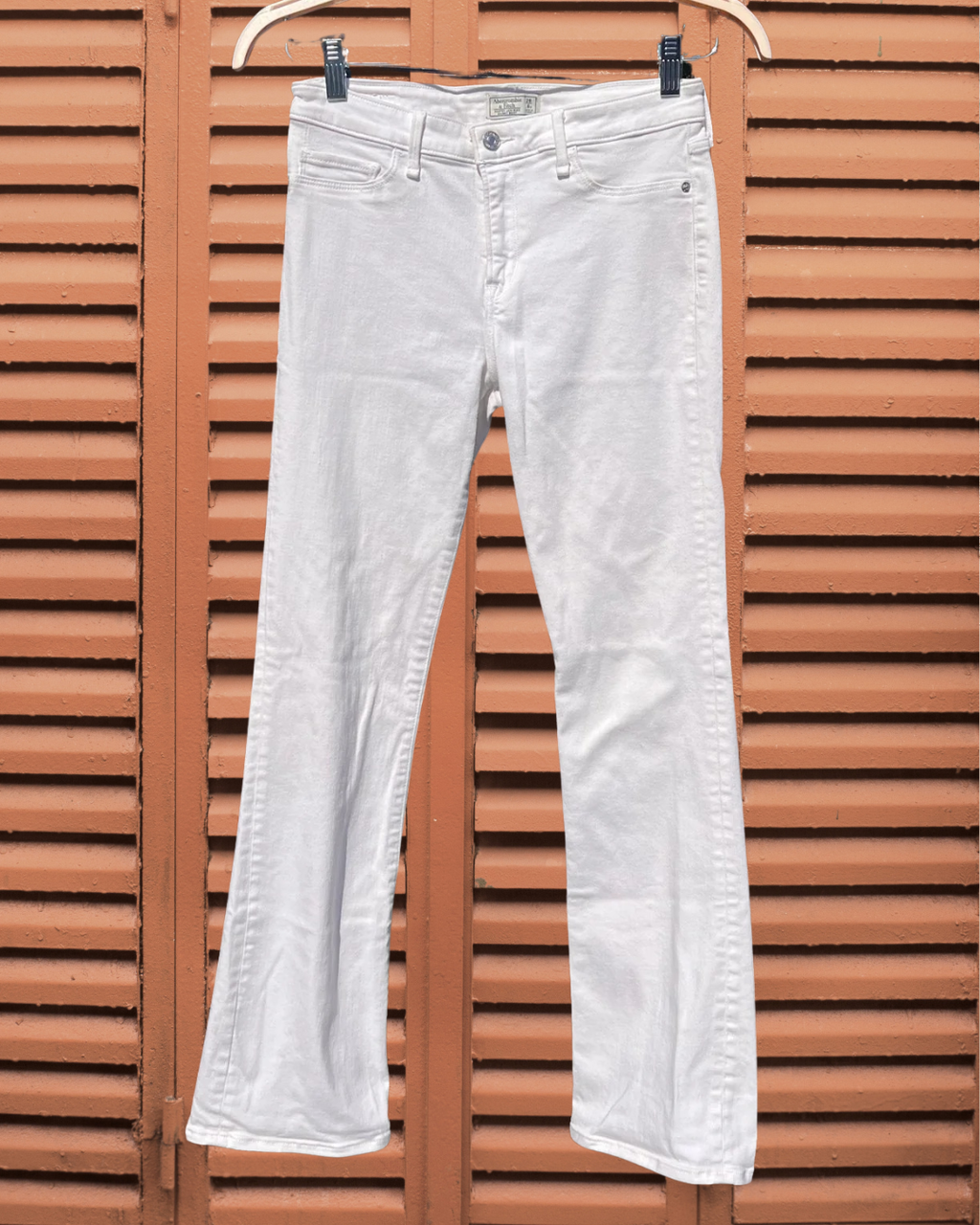 White jeans hanging on a wooden background