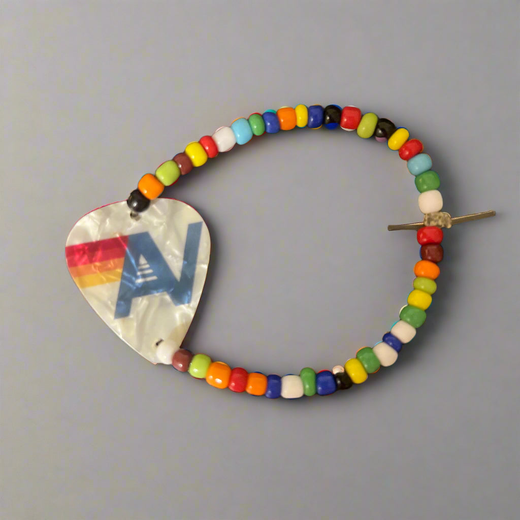 Colorful beaded hair clip with a heart-shaped metal piece on a gray background