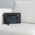 Black leather clutch bag on a textured surface