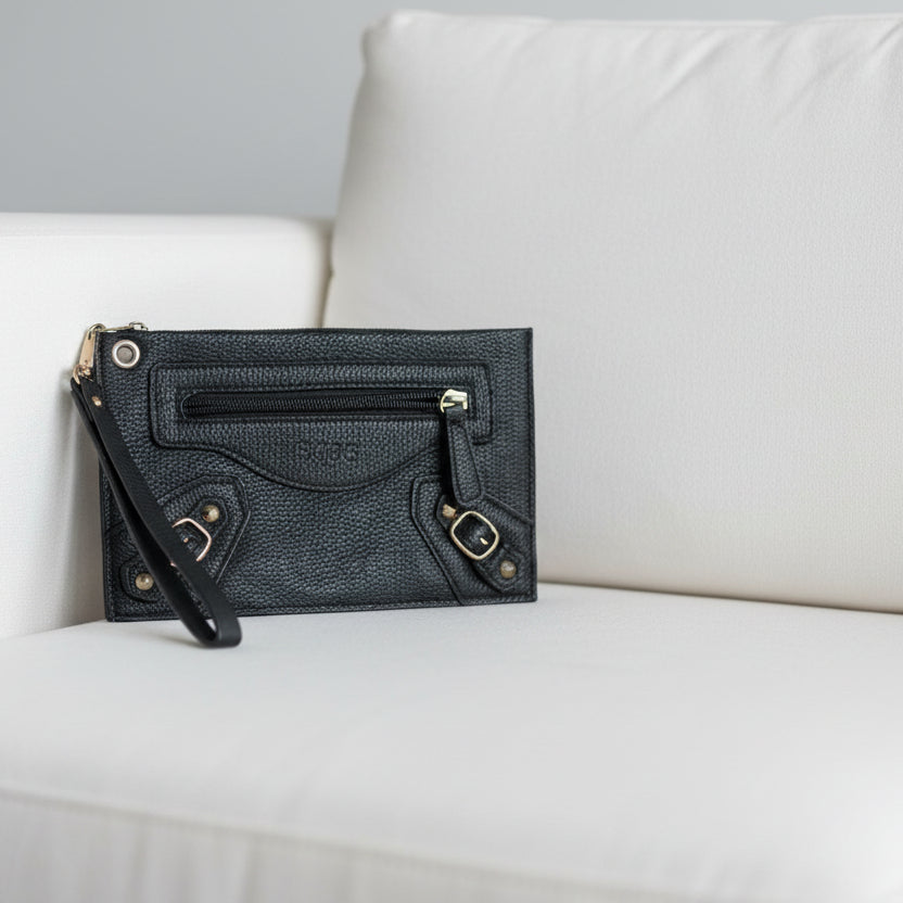 Black leather clutch bag on a textured surface
