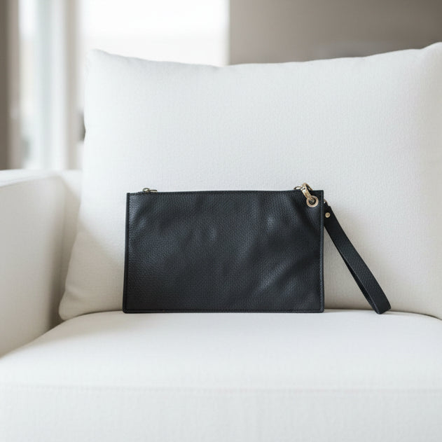 Black wristlet wallet on a white sofa