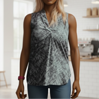 Woman wearing a patterned sleeveless top in a bright room with wooden shelves.