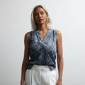 Woman wearing a sleeveless patterned top against a white background