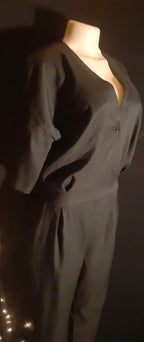 Mannequin wearing a dark gray outfit against a dark background