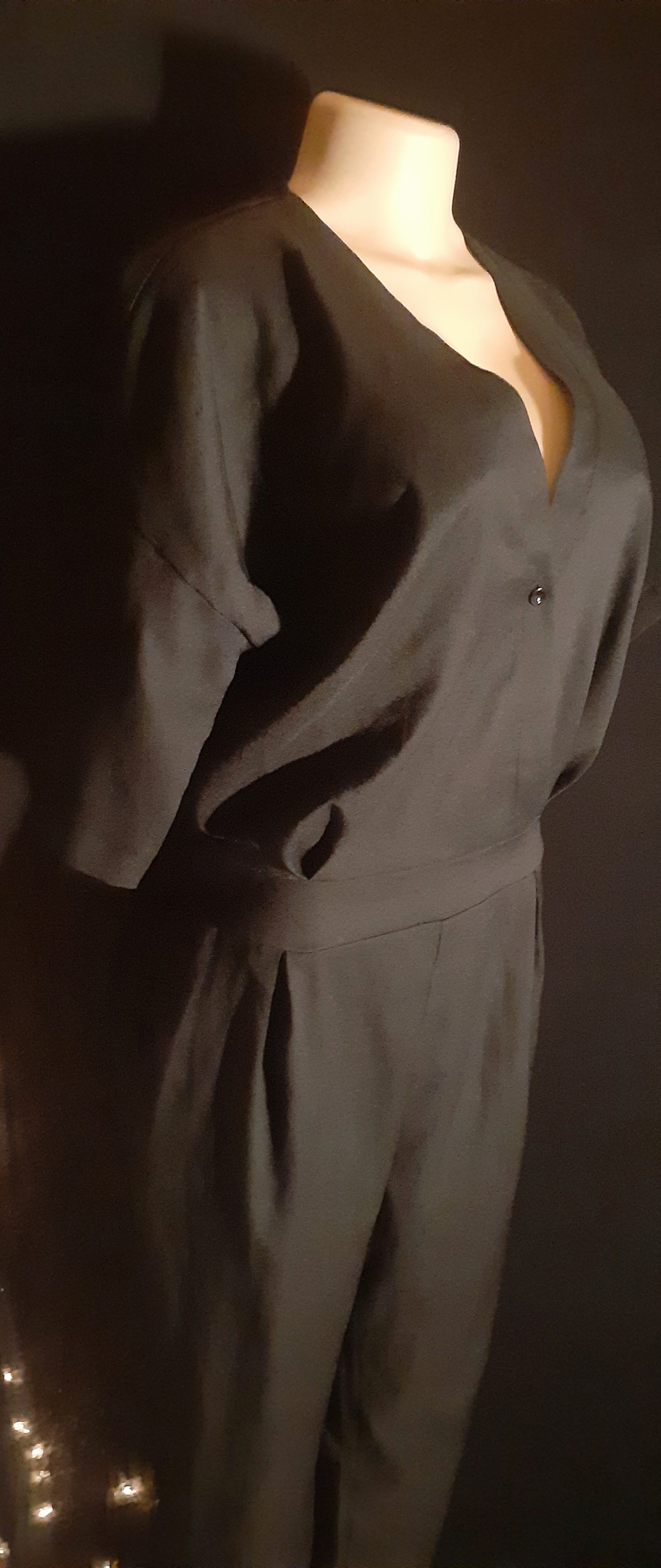 Mannequin wearing a dark gray outfit against a dark background