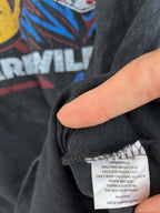 Close-up of a person's hand holding open a black graphic t-shirt to show the inner care label.
