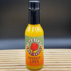 Bottle of Hawaiian Lava hot sauce on a wooden surface with a dark background