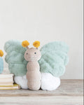 Two plush caterpillar toys on a wooden surface with a plain background