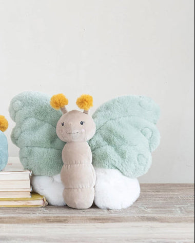 Two plush caterpillar toys on a wooden surface with a plain background