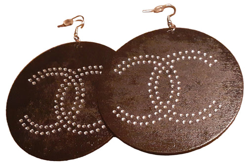 Pair of earrings with 'π' symbol design on a brown surface