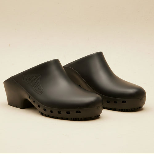 Pair of black clogs on a white background