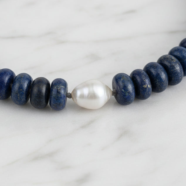 Necklace with blue beads and a white pearl