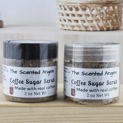 Two jars of coffee sugar scrub on a wooden surface with a neutral background.