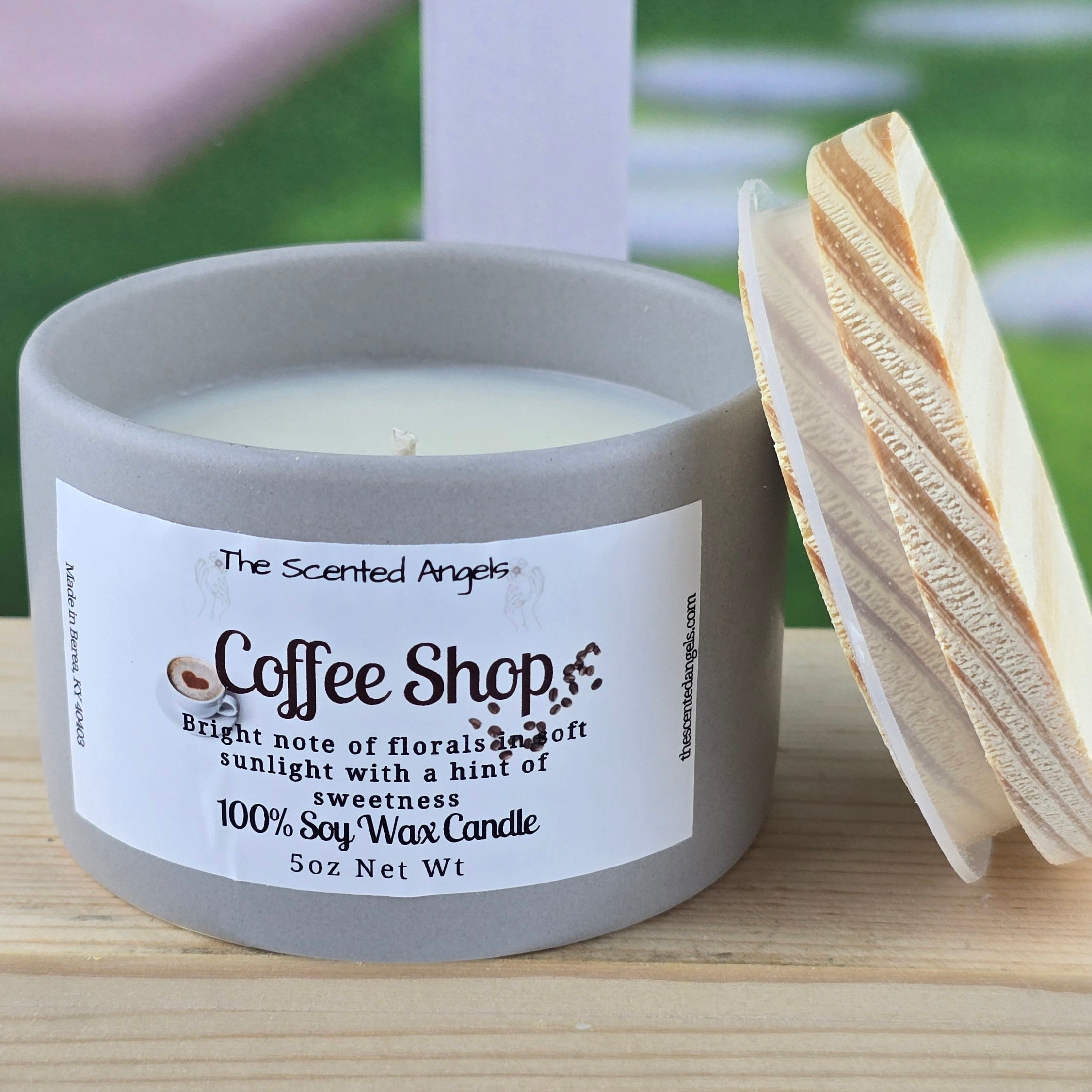 Candle labeled 'Coffee Shop' with a wooden lid on a wooden surface