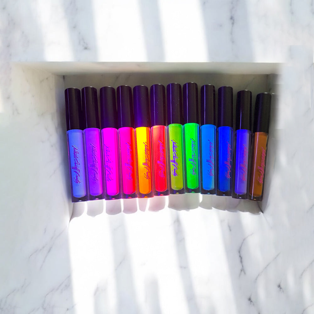 Row of colorful lip glosses on a marble shelf