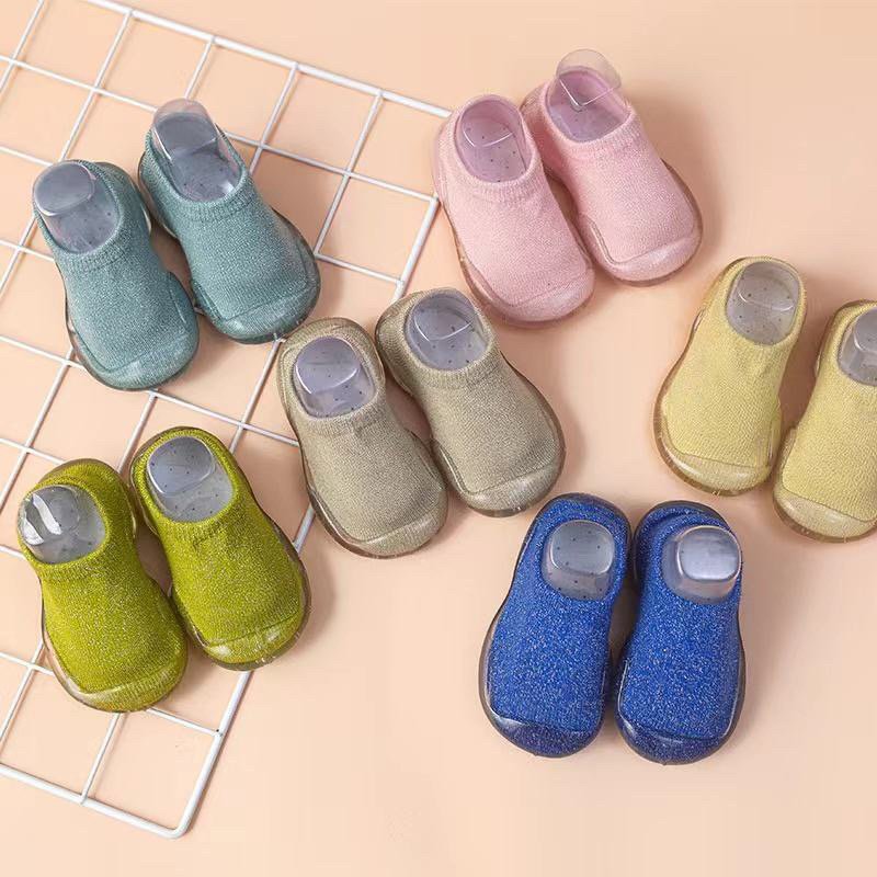Colorful children's slippers on a grid background