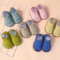 Colorful children's slippers on a grid background