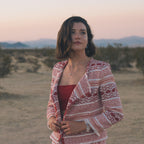 Woman standing in a desert landscape with mountains in the background