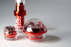 Red skincare product with a clear sphere on a gray background