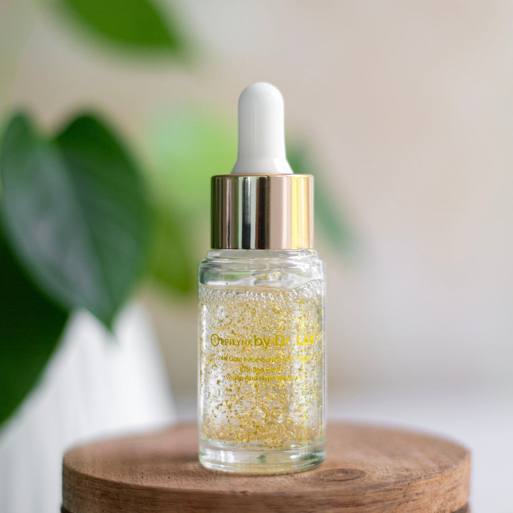 Glass dropper bottle with gold liquid on a wooden surface with a blurred green plant background