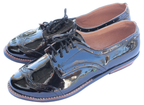 Shiny black shoes with laces on a white background