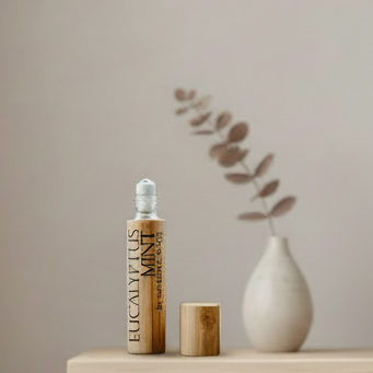 Wooden essential oil bottle with dropper on a green platform with palm leaf patterns