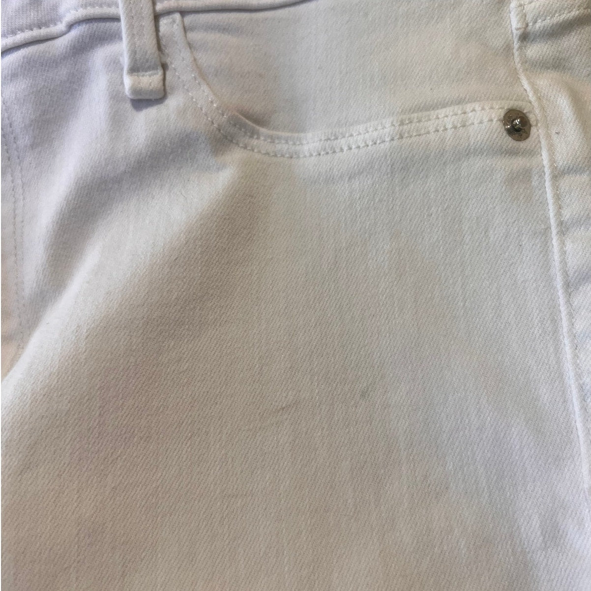 Close-up of light-colored denim fabric with stitching details