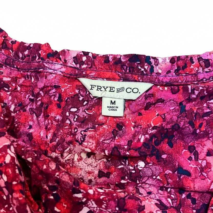 Close-up of a pink patterned fabric with a 'Frye and Co.' label.