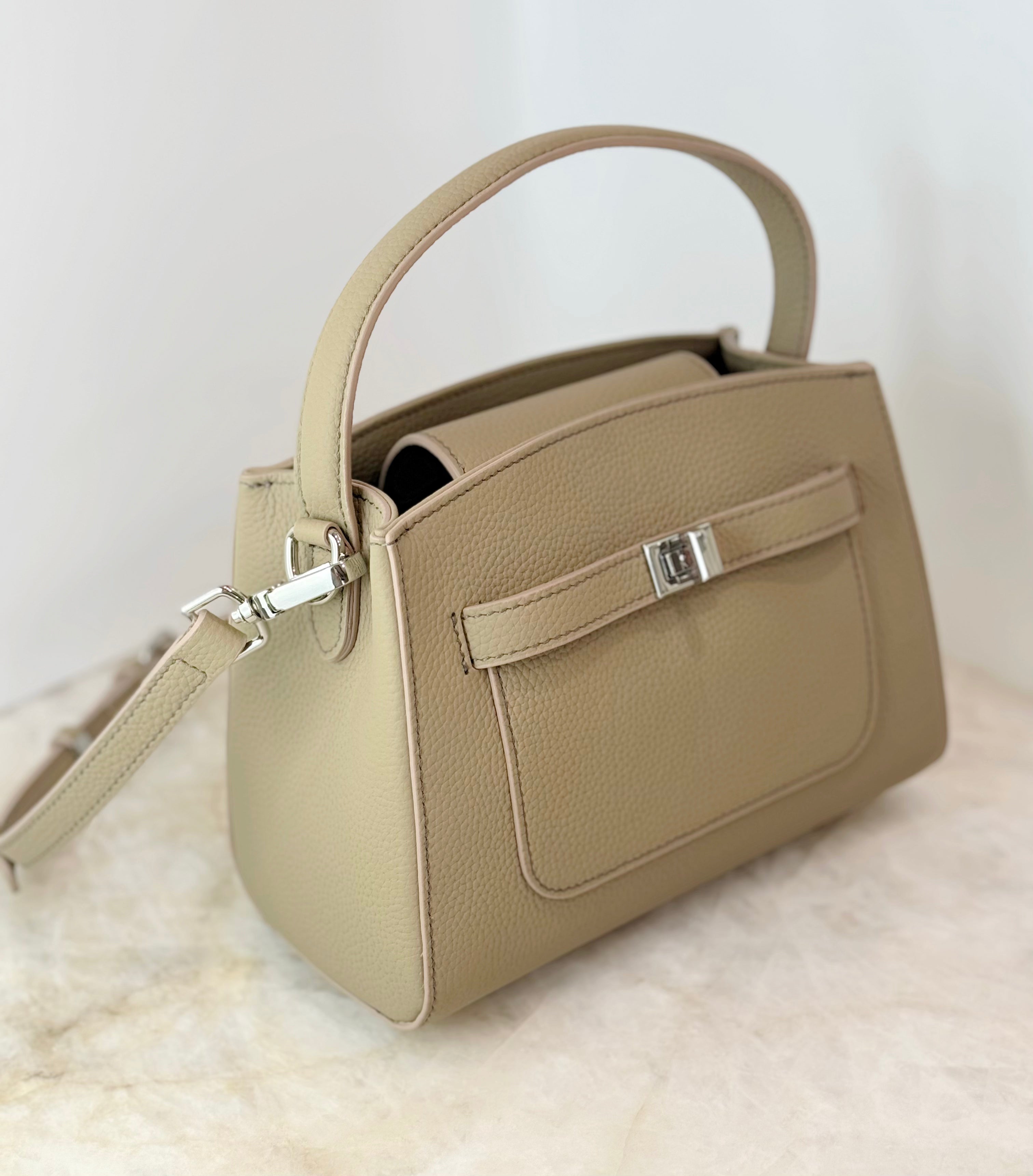 Beige handbag with a visible brand logo on a light background