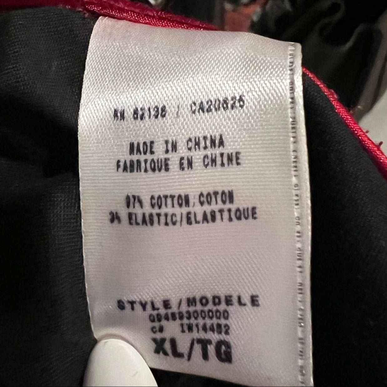 Fabric tag on clothing with text indicating 'Made in China' and material composition.