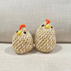 Two knitted chicken toys on a light background