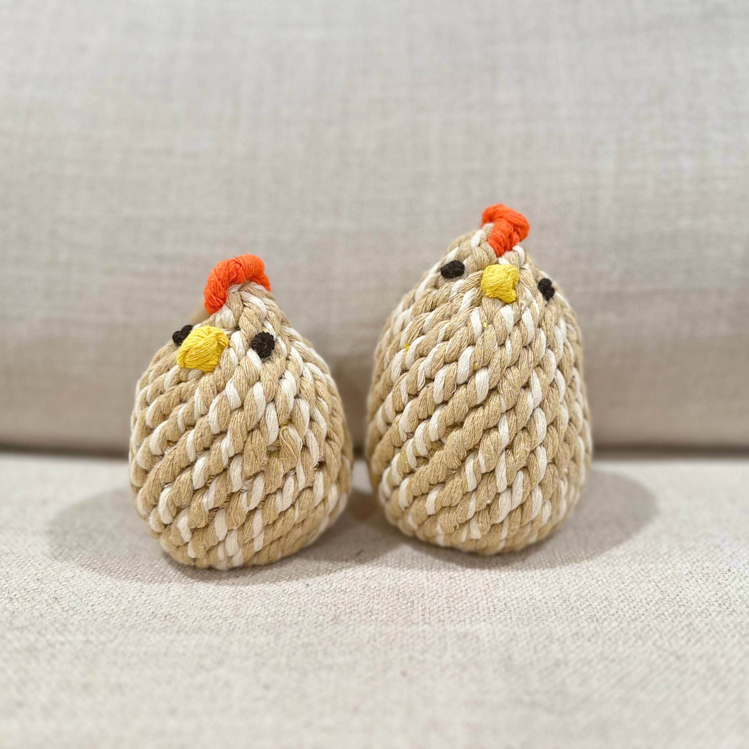 Two knitted chicken toys on a light background