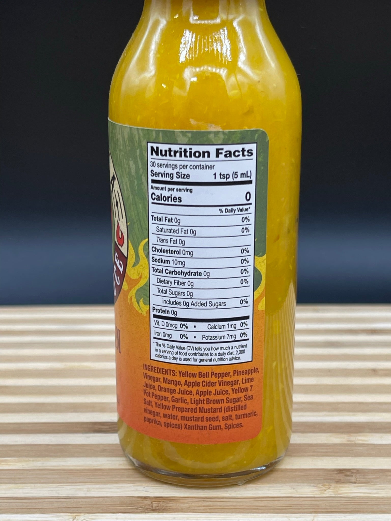 Bottle of hot sauce with nutrition label on a wooden surface