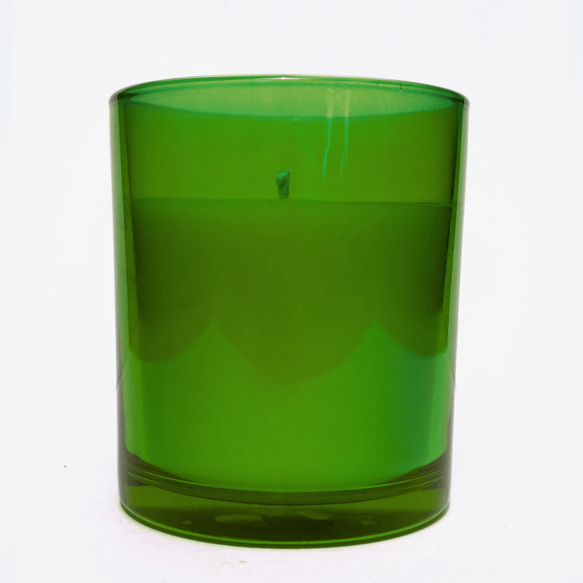Green candle in a glass container on a white background