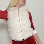 Person wearing a white fluffy vest over a red outfit on a plain background