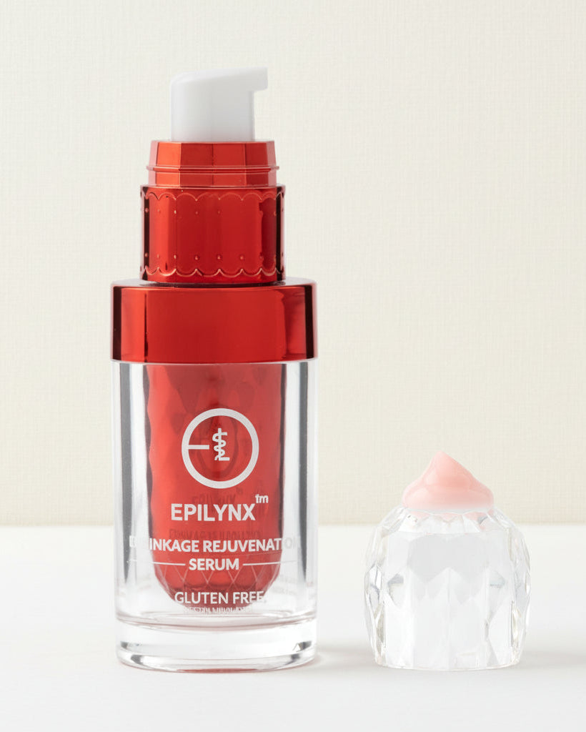 Red skincare serum bottle with applicator on a white background