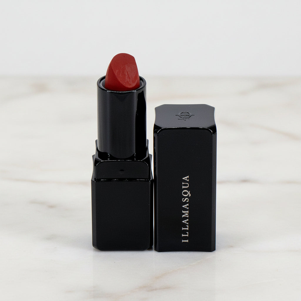 Red lipstick with black casing on a white background, featuring the Illamasqua brand.