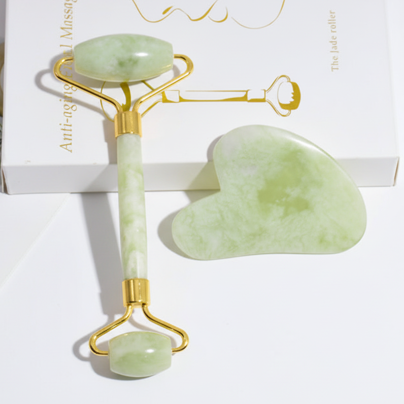 Green jade roller and gua sha tool on a white background