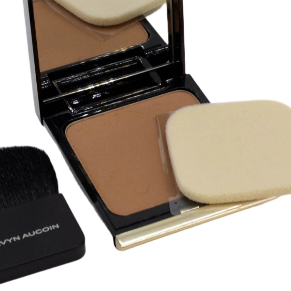 Compact powder with mirror, brush, and sponge applicator on a white background