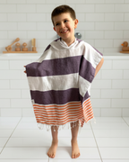 Child wearing a striped towel in a bathroom