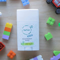 BeNat Kids natural deodorant stick surrounded by colorful building blocks on a wooden surface