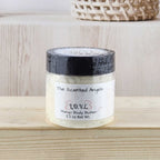 Jar of body butter on a wooden surface with a neutral background