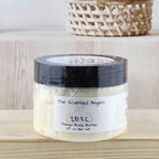 Jar of body butter on a wooden surface with a neutral background