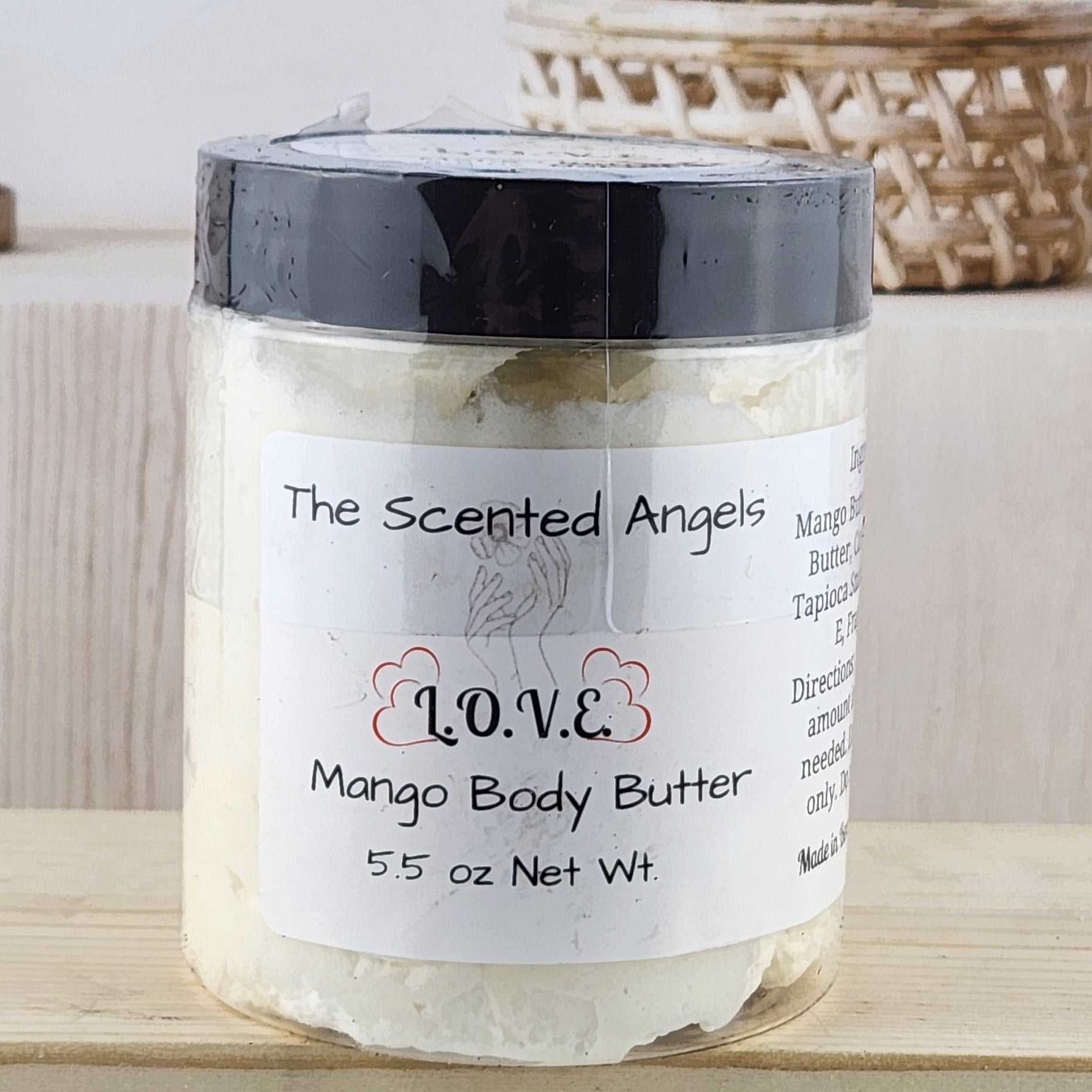 Jar of Mango Body Butter with 'The Scented Angels' label on a wooden surface.